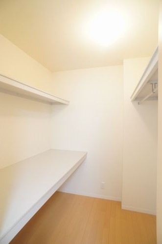 収納　棚机とハンガーパイプを配したウォークインクローゼット