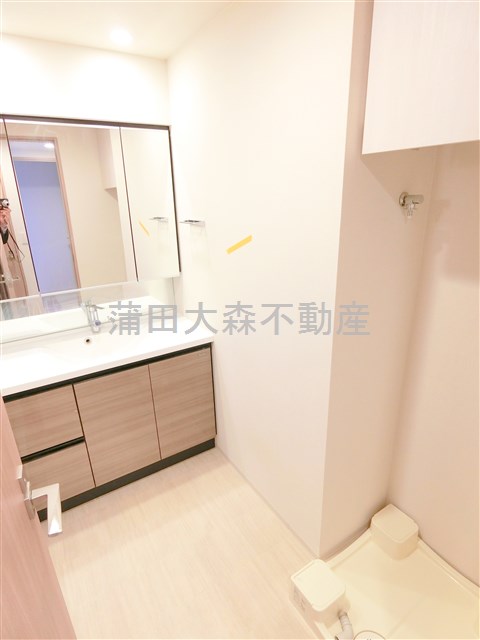 洗面設備　3面鏡の独立洗面台　吊戸棚付きの洗濯機置き場　洗面脱衣所