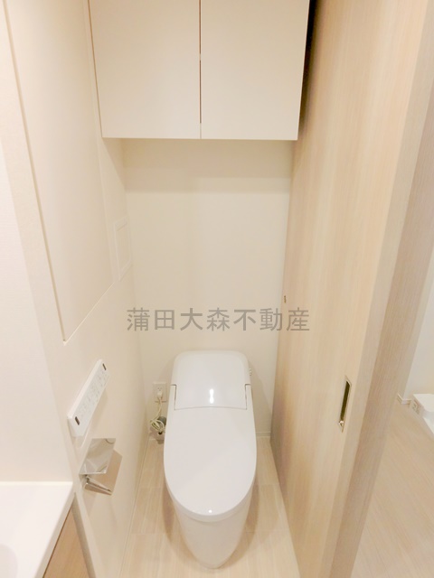 トイレ　吊戸棚収納と温水洗浄便座付きのトイレ