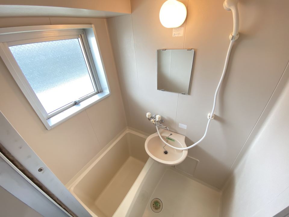バス・シャワールーム　洗面台と鏡付きの浴室です