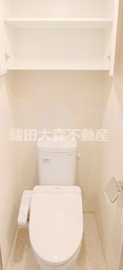 トイレ　吊戸棚収納と温水洗浄便座付きのトイレ