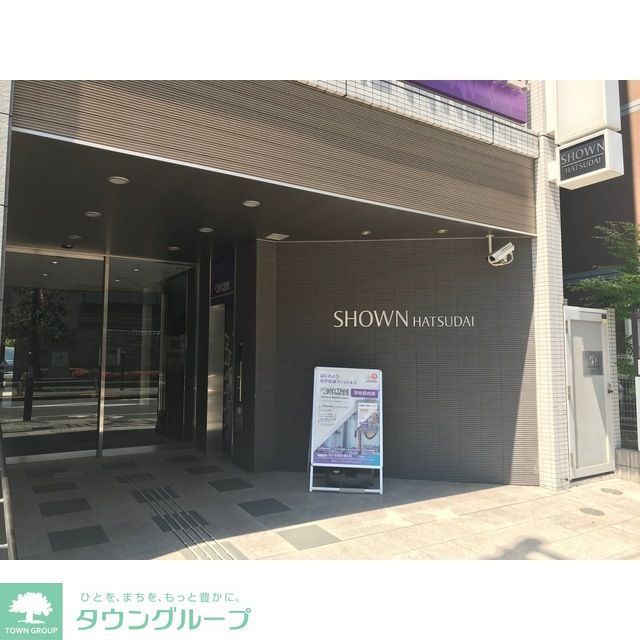 エントランス　自動ドア手前は2F店舗用エレベーター、右側白い扉は非常階段…