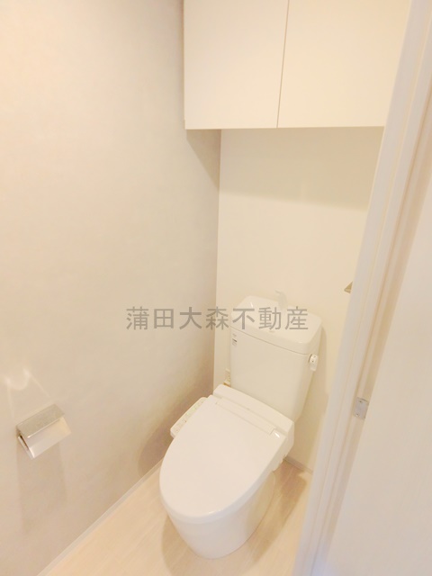 トイレ　吊戸棚収納と温水洗浄便座付きのトイレ
