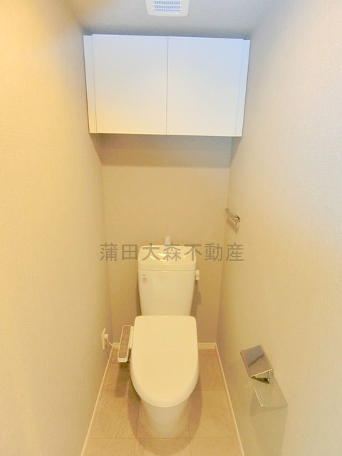 トイレ　吊戸棚収納と温水洗浄便座付きのトイレ