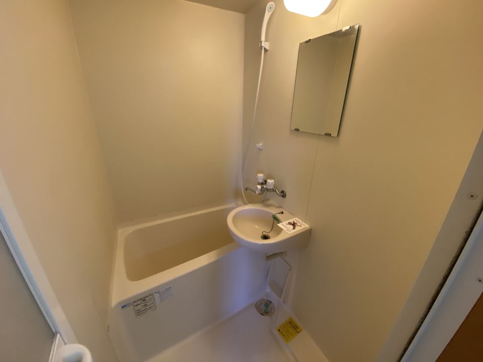 バス・シャワールーム　洗面台と鏡付きの浴室です