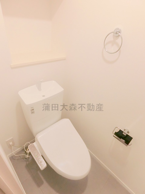 トイレ　棚と温水洗浄便座付きのトイレ