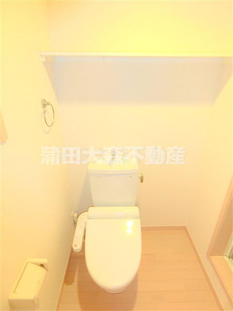トイレ　棚と温水洗浄便座付きのトイレ