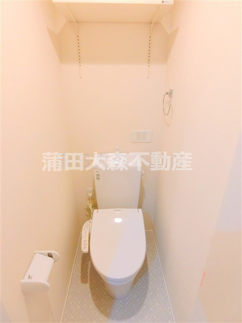 トイレ　棚と温水洗浄便座付きのトイレ