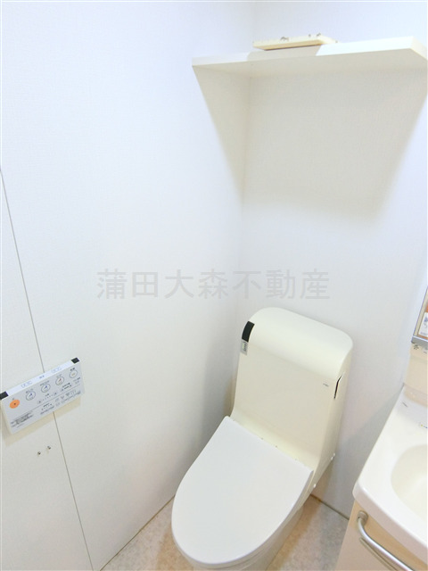 トイレ　棚収納とと温水洗浄便座付きのトイレ