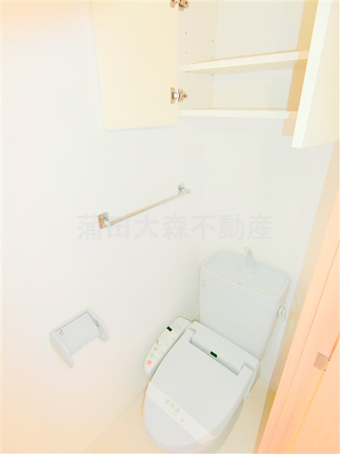 トイレ　吊戸棚と温水洗浄便座付きのトイレ