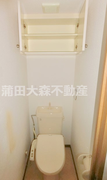 トイレ　吊戸棚収納と温水洗浄便座付きのトイレ
