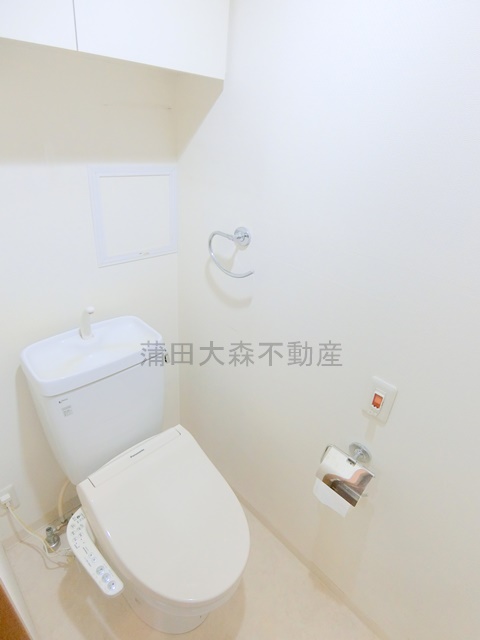 トイレ　吊戸棚と温水洗浄便座のトイレ