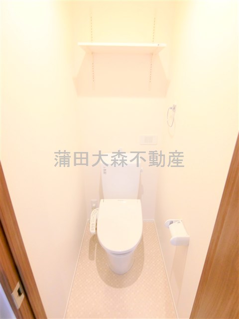 トイレ　棚と温水洗浄便座付きのトイレ