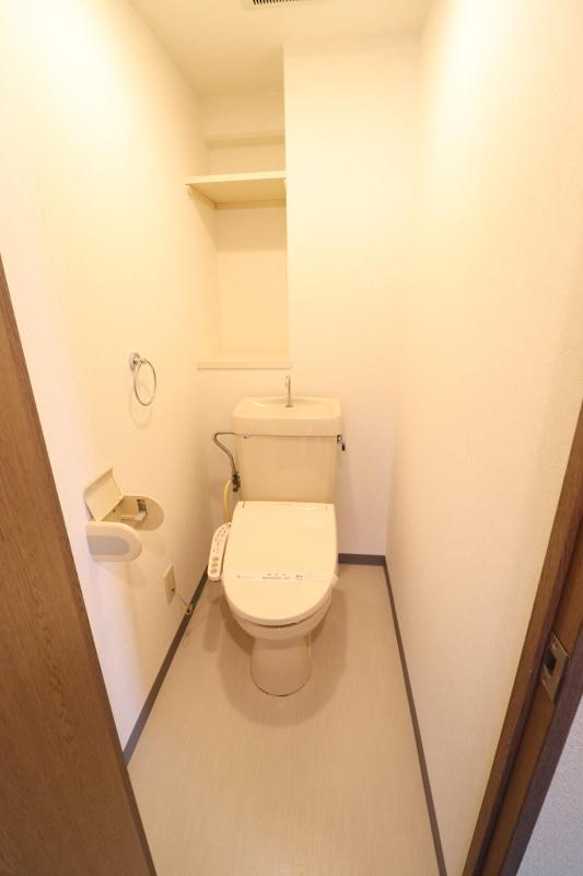 トイレ　温水洗浄便座付きのトイレ　上部に棚あり。