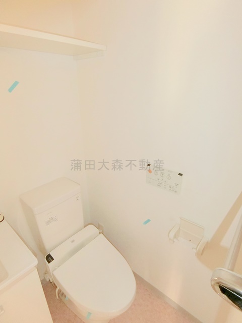 トイレ　吊り棚と温水洗浄便座付きのトイレ