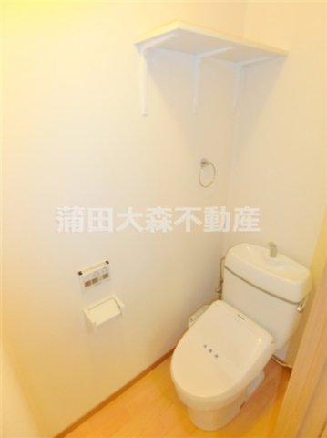 トイレ　棚と温水洗浄便座付きのトイレ