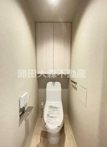 トイレ　吊戸棚収納と温水洗浄便座付きのトイレ