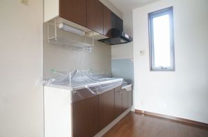 キッチン　壁付けのキッチンは換気と採光を考慮した小窓と上下に豊富な収納