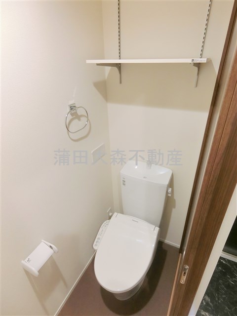トイレ　棚と温水洗浄暖房便座付きのトイレ