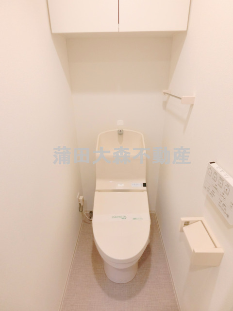 トイレ　上部棚収納に温水洗浄便座付きのトイレ