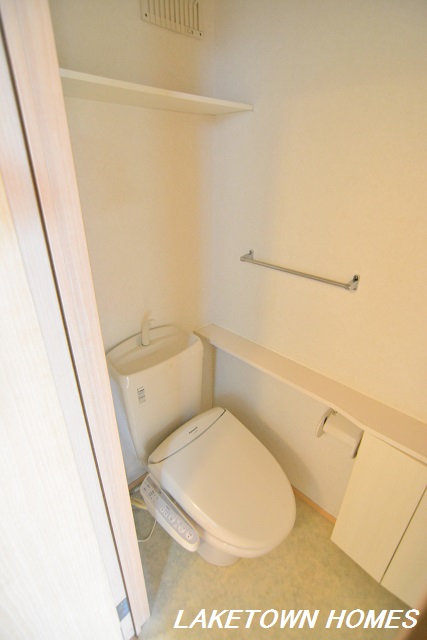 トイレ　上部と脇に収納のある温水洗浄便座付のトイレです。
