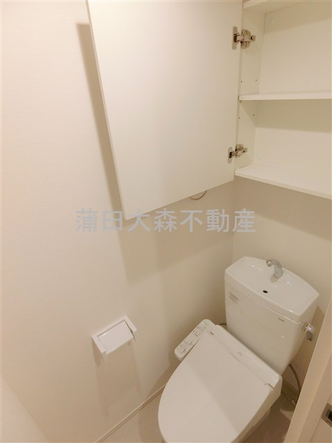 トイレ　吊戸棚と温水洗浄便座付きのトイレ