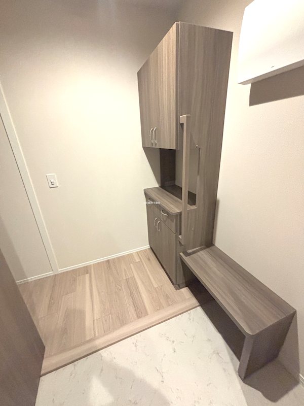 玄関　靴を脱いだり履いたりする時の転倒リスクに備え、手すりとベンチ