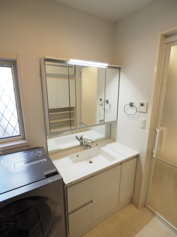 洗面設備　三面鏡と広々とした洗面台。シャンプードレッサー付きなので頭も