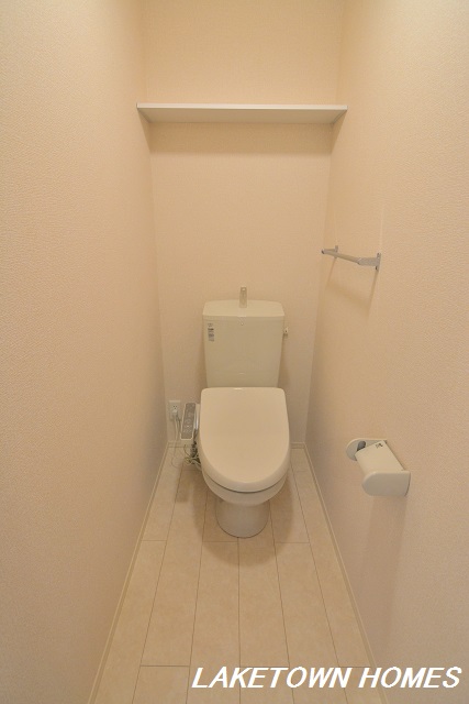 トイレ　上部に収納棚がある温水洗浄暖房便座付のトイレです。