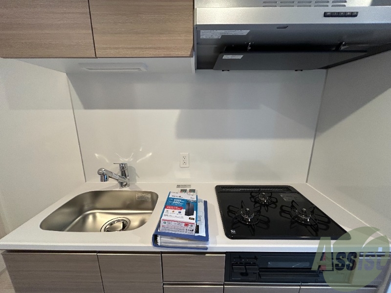 キッチン　３口のガスコンロとグリルが設置済みのシステムキッチンです。