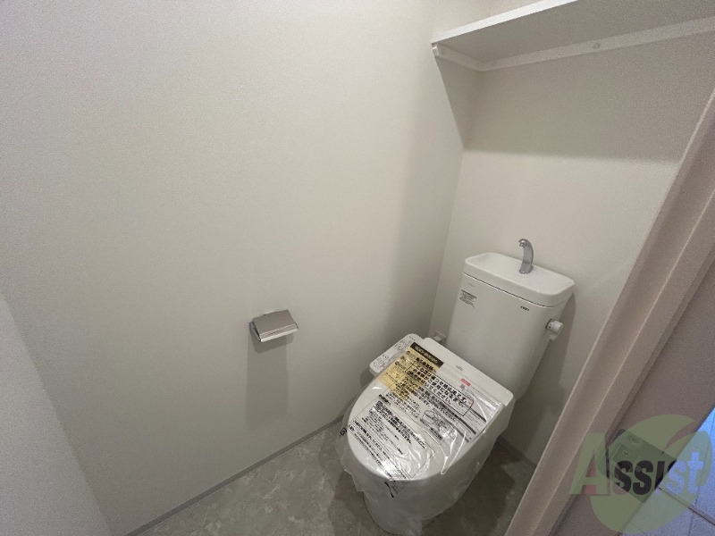 トイレ　トイレには温水洗浄便座がついています。上段に棚もありますね。