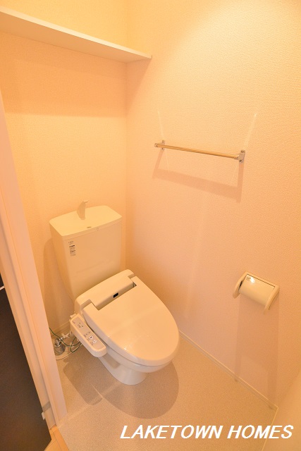 トイレ　上部に収納棚がある温水洗浄暖房便座付のトイレです。