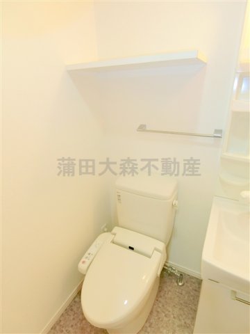 トイレ　棚と温水暖房便座付きのトイレ