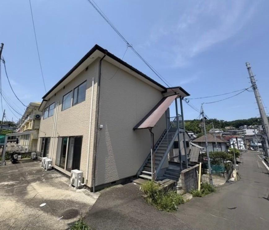 建物外観　日当たり良好で明るい住環境。青空に映える落ち着いた外観です。
