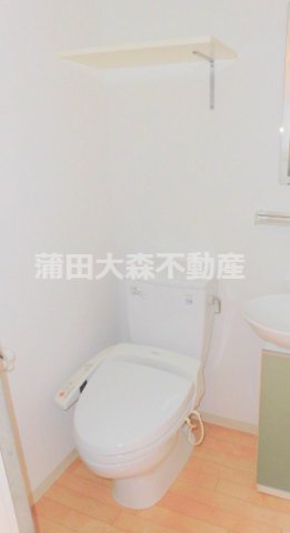 トイレ　棚と温水洗浄便座付きのトイレ