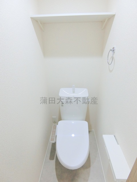 トイレ　棚と温水洗浄便座付きのトイレ