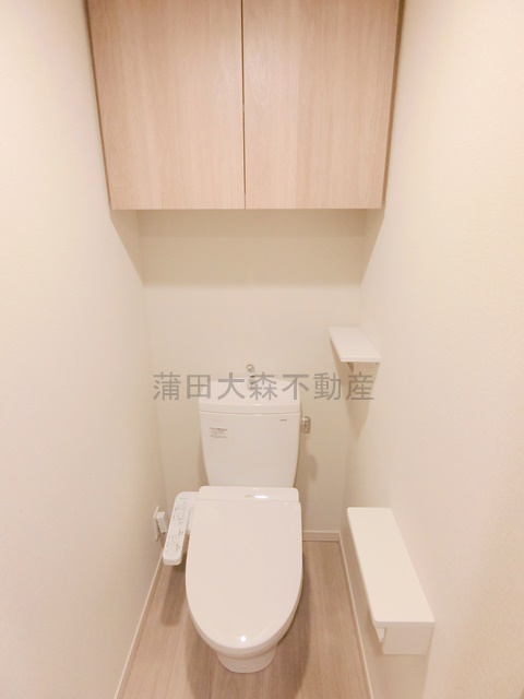 トイレ　吊戸棚収納と温水洗浄便座付きのトイレ