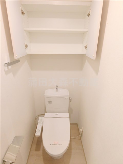 トイレ　吊戸棚収納と温水洗浄便座付きのトイレ