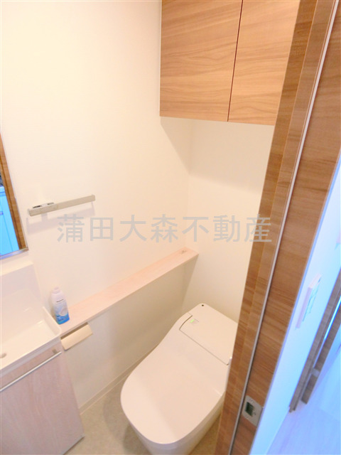 トイレ　棚収納と手洗い温水洗浄便座付きのトイレ