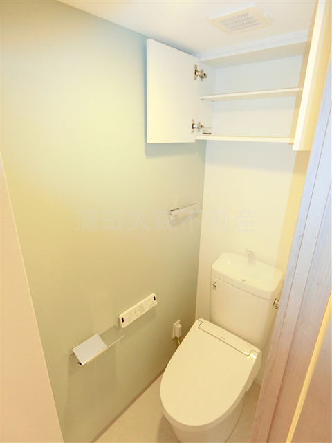 トイレ　棚収納とと温水洗浄便座付きのトイレ