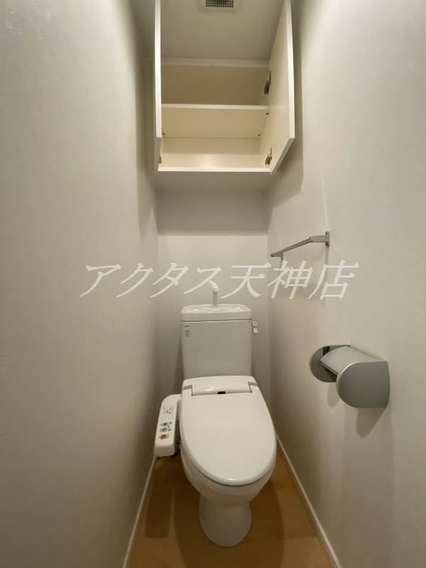 トイレ　上部に扉付き棚があります。