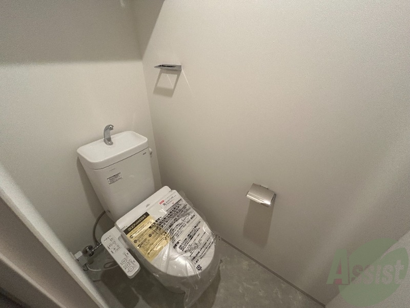 トイレ　トイレには温水洗浄便座がついています。上段に棚もありますね。