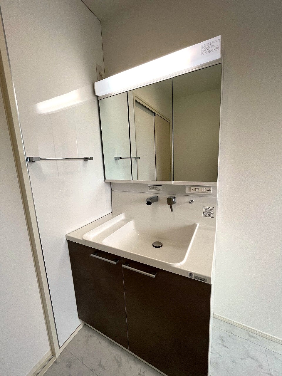 洗面設備　三面鏡付洗面台。物干し付で室内干しもラクラク。