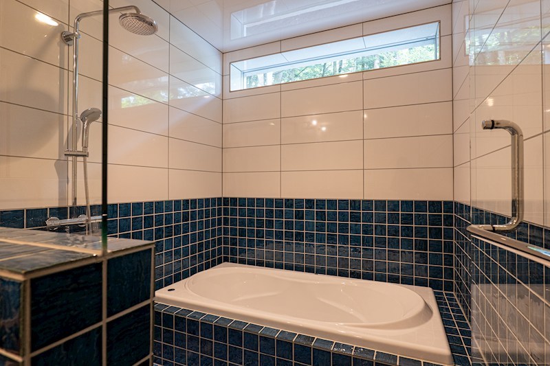 バス・シャワールーム　洗面スペースと統一感を持たせたブルーのタイルが、リゾート地な