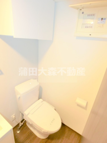 トイレ　吊戸棚と温水洗浄便座付きのトイレ