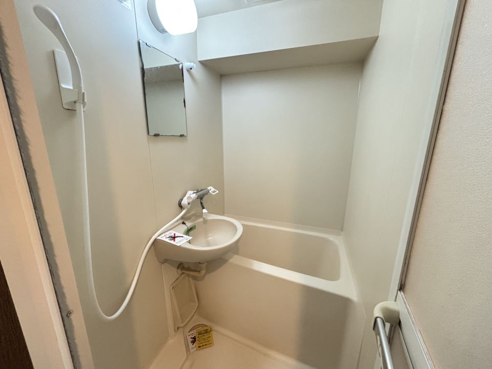 バス・シャワールーム　洗面台と鏡付きの浴室です