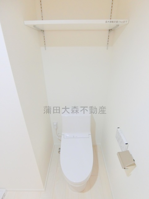 トイレ　棚と温水洗浄便座付きのトイレ