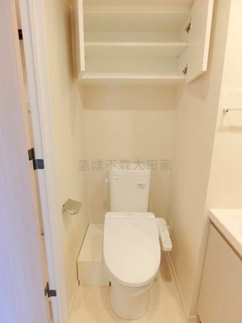 トイレ　吊戸棚収納と温水洗浄便座付きのトイレ