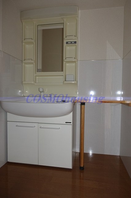 洗面設備　洗面台横に棚が取付てあります。