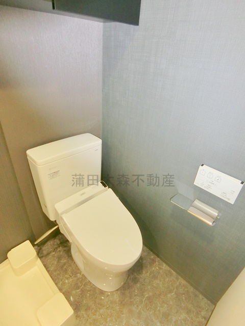 トイレ　吊戸棚と温水洗浄便座付きのトイレ